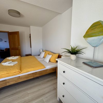 Ferienwohnung Strandflieder - Doppelbett und Kommode